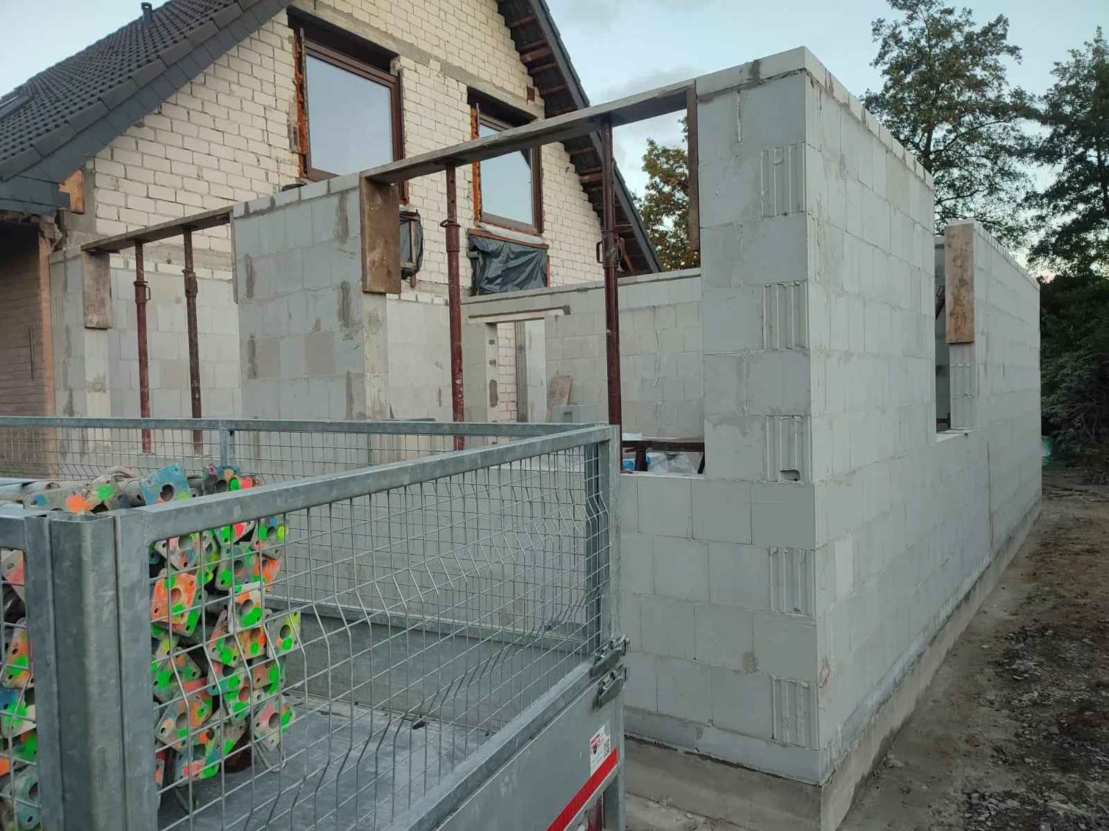 Rohbau eines Anbaus mit Stahlträgern und Baustützen, Wände bereits hochgezogen